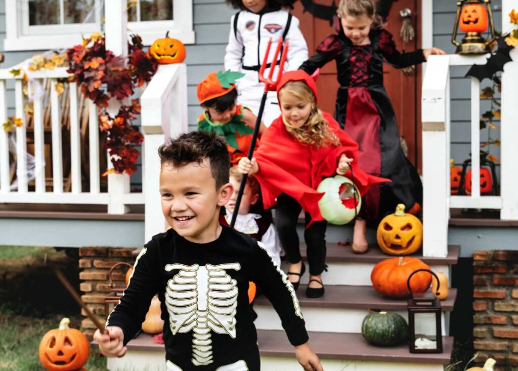 Kids trick or treating leaving a home practicing good halloween safety