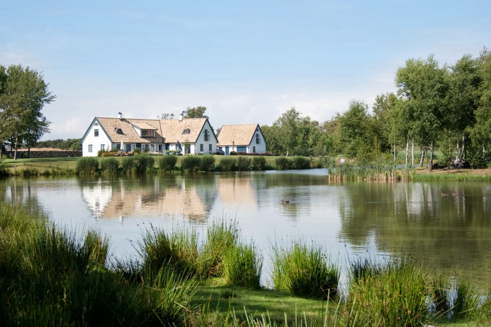 A large vacation home on a pond protected by vacation home security systems