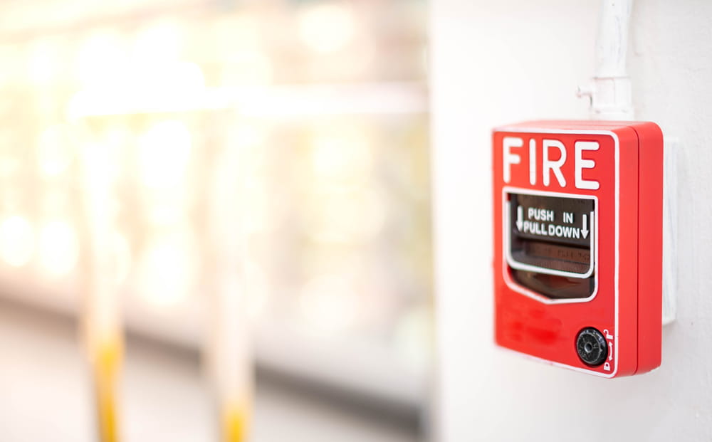 A fire alarm pull in an office setting for a monitored fire alarm system